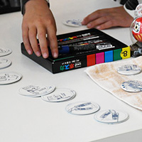 A visitor making his own tin badge