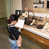 A girl figuring out the workbook at the Mobile Communications corner