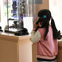 A girl trying out the black telephone