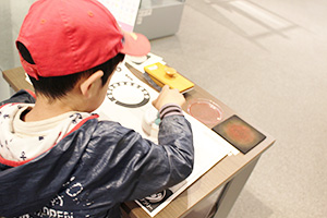 A boy impressing a stamp on his stamp card