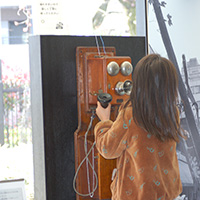 デルビル磁石式電話機を体験する子どもの写真